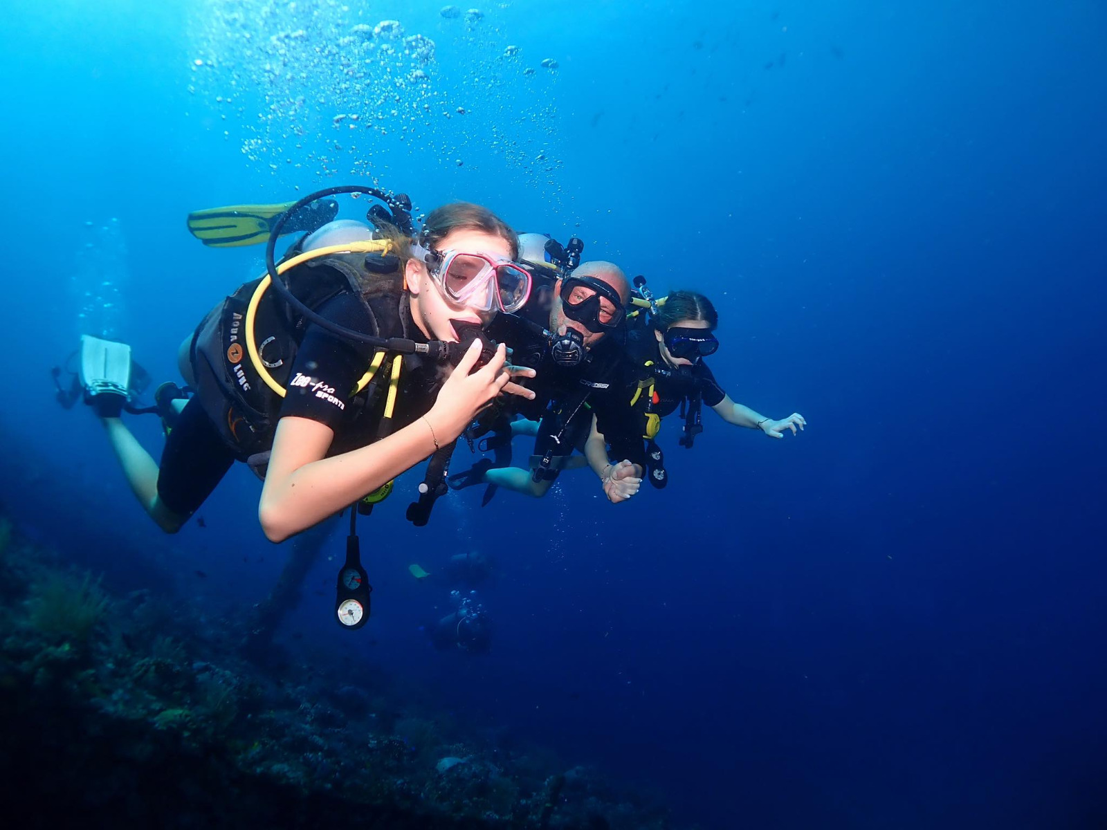 PADI instructor with two students during a small-group scuba lesson in Amed